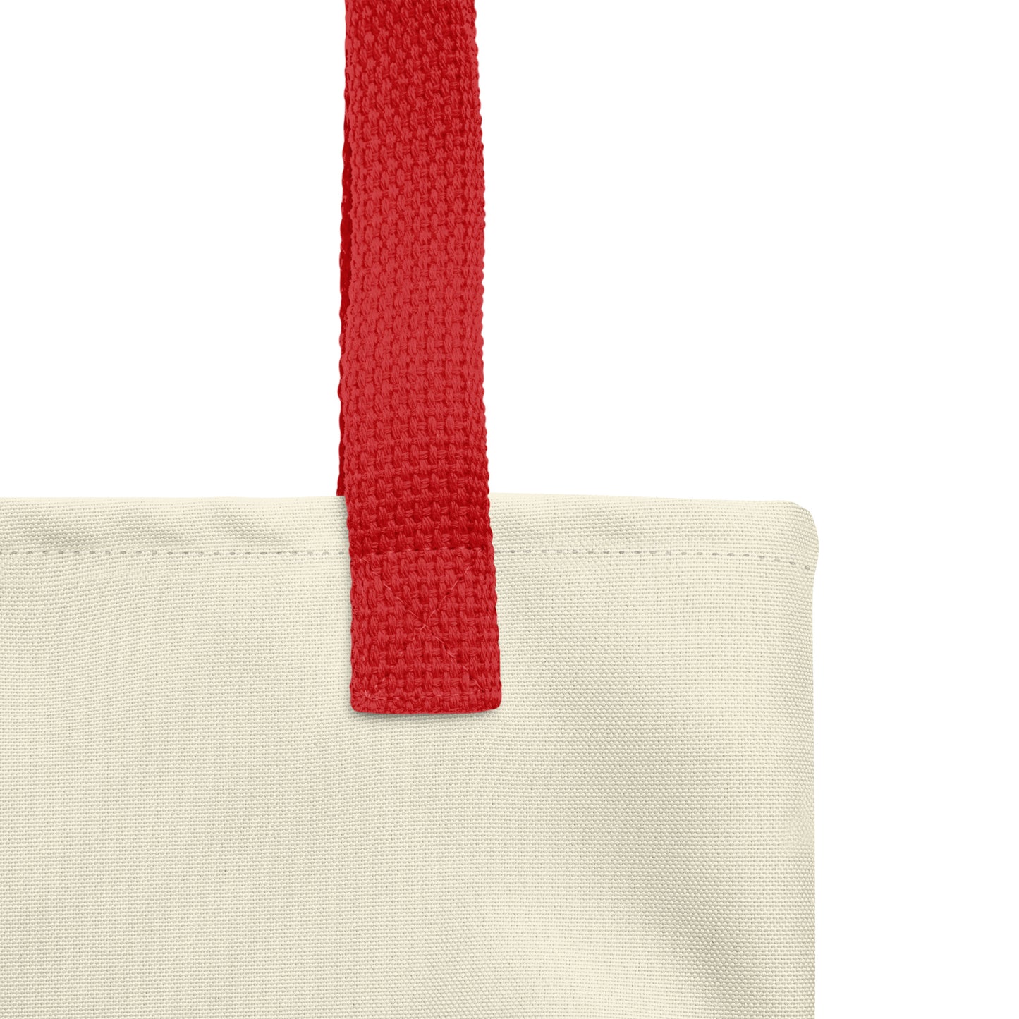 Close-up of a cream Christian tote bag showing the red woven handle, fabric texture, stitching, and neutral tote material.