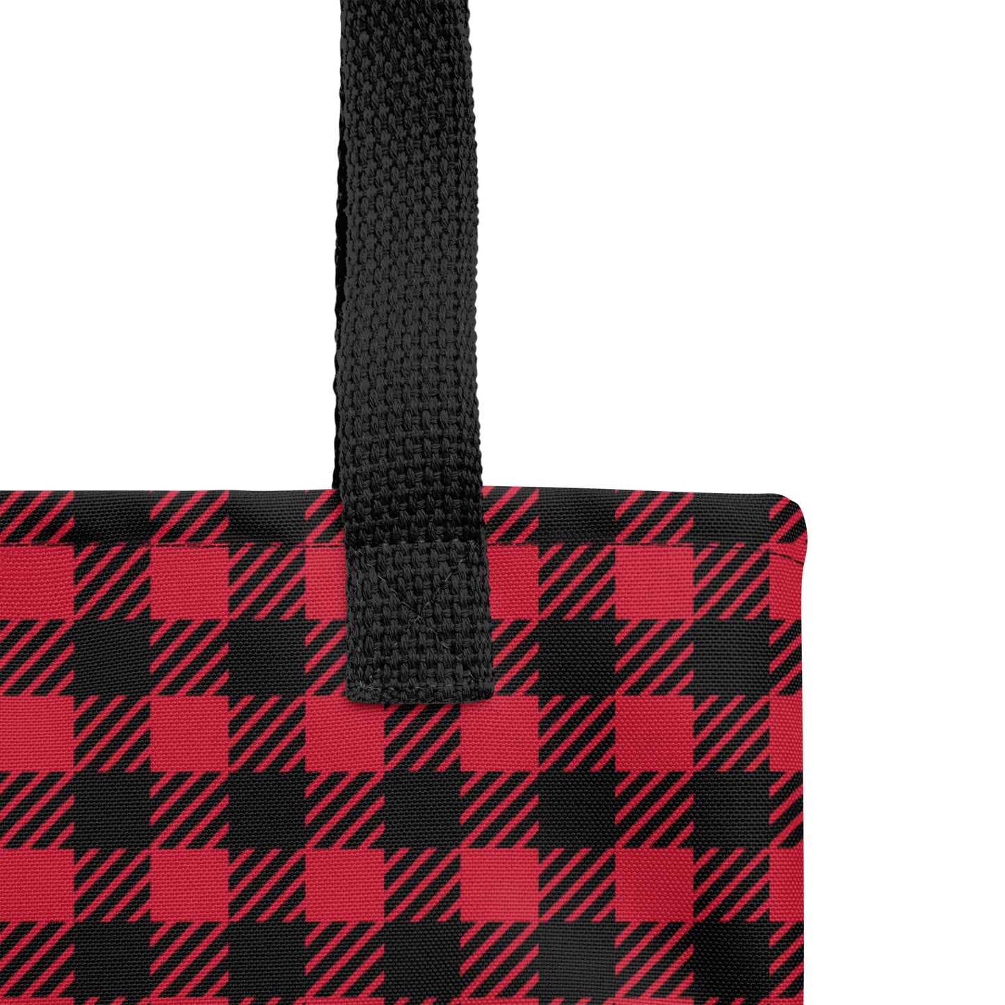 Close-up of the red and black plaid tote fabric and black strap, highlighting the stitching, textured canvas, and buffalo check pattern.