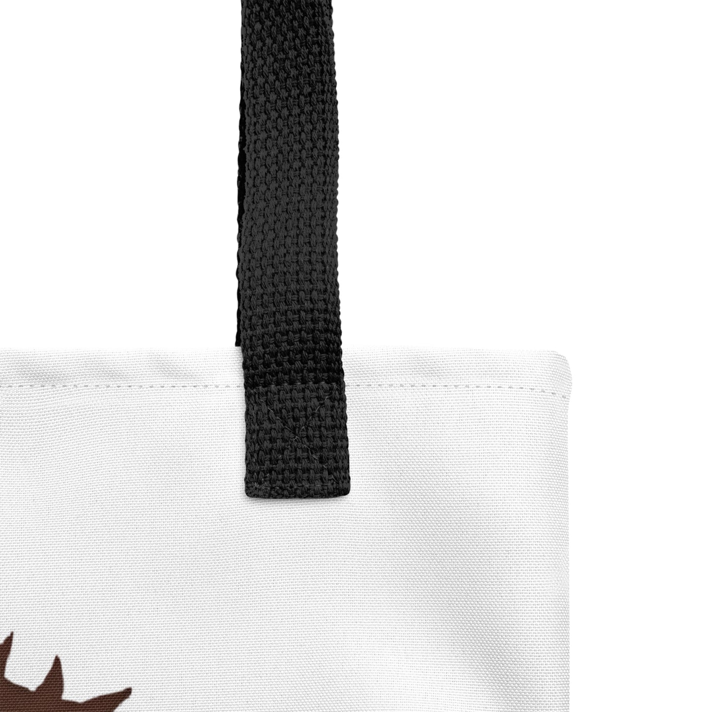 Close-up of the white tote fabric and black strap, highlighting the stitching, textured canvas, and strap weave detail.