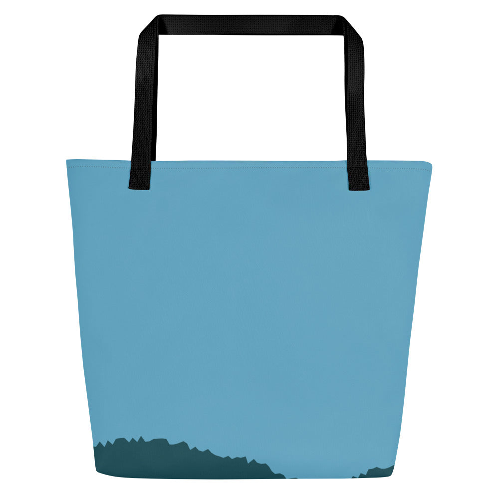 Back view of tote bag with black straps and a solid light sky-blue back panel, with a dark teal silhouette along the bottom edge.