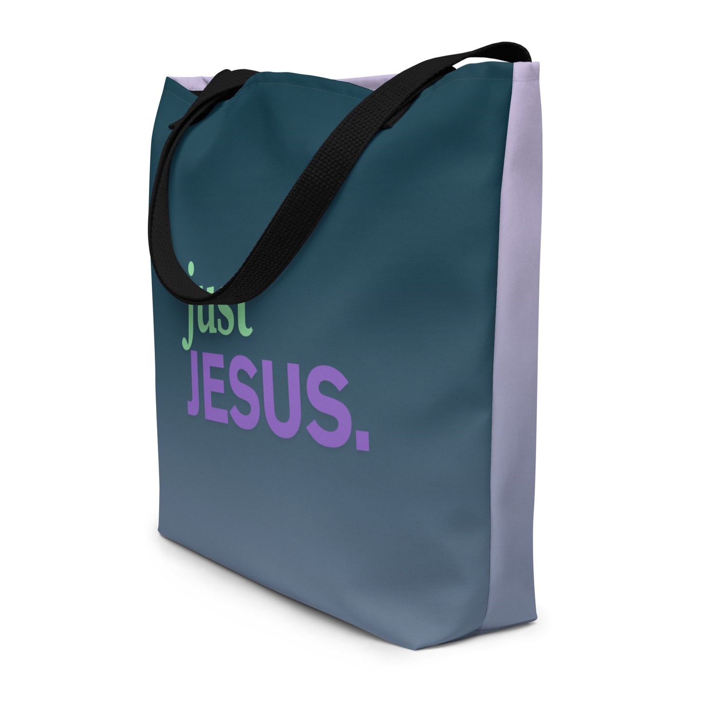 Angled view of dark teal tote bag with black straps and “just JESUS.” text in green and purple.