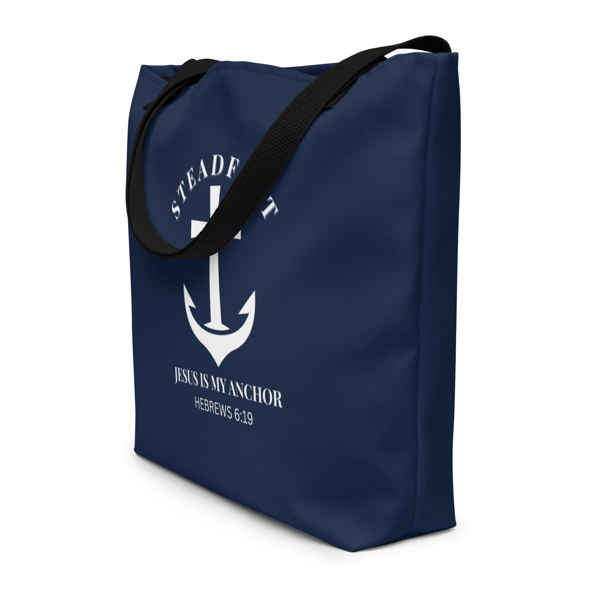 Angled view of navy tote bag with black straps and white “Steadfast” anchor-and-cross graphic with Hebrews 6:19.