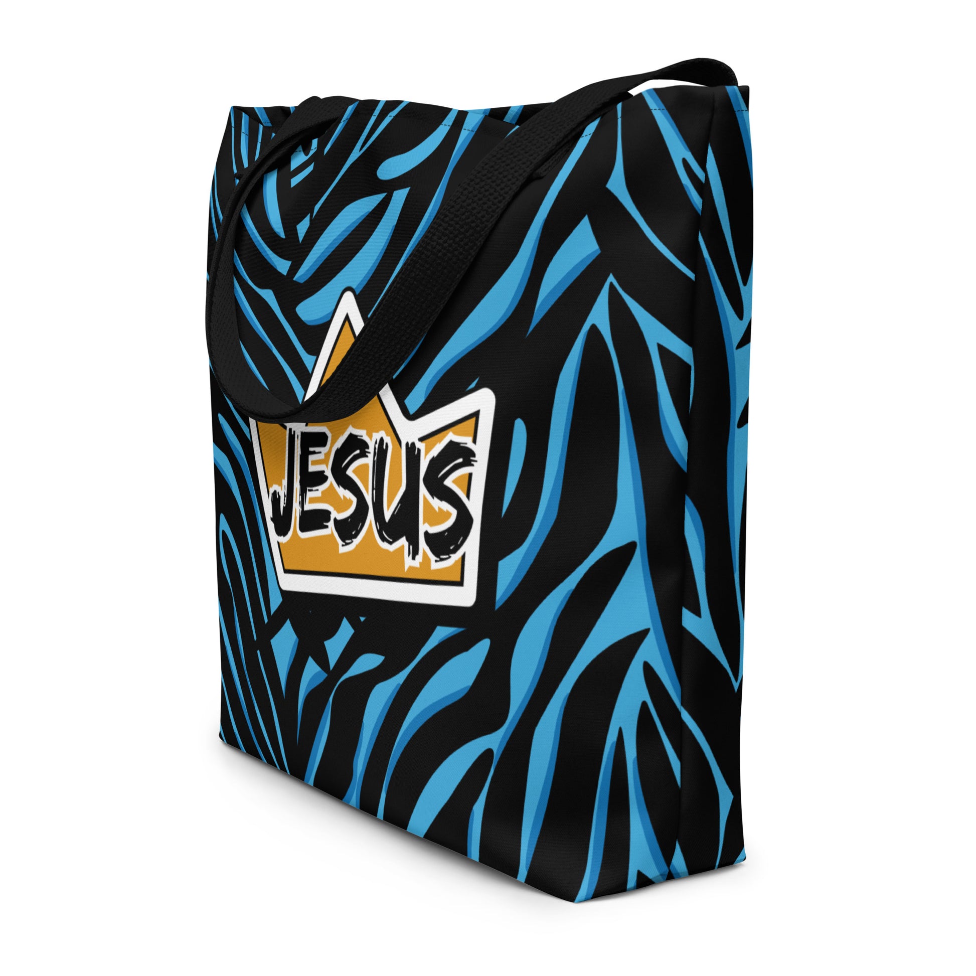 Angled view of the tote showing the black-and-blue zebra-style pattern wrapping around the sides and the centered yellow crown “JESUS” graphic on the front; black straps hang over the top edge.