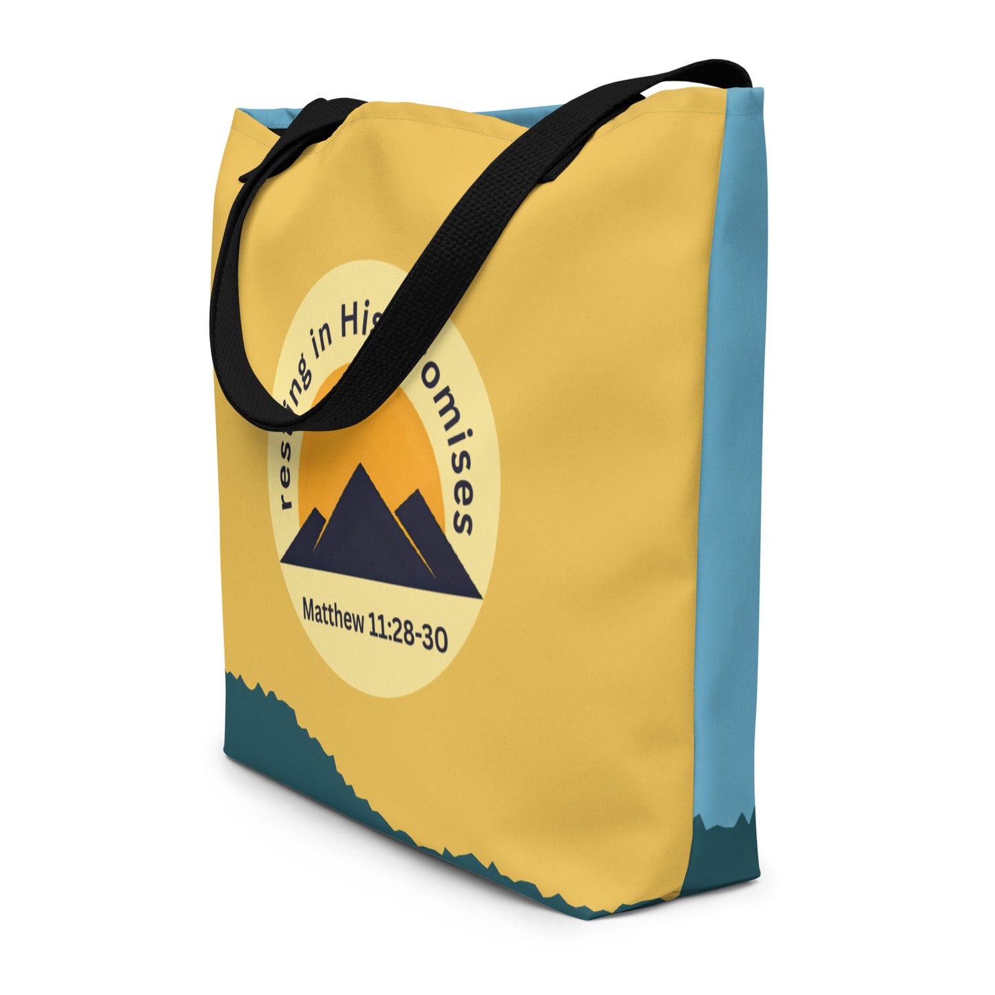 Angled view of the tote showing the wraparound design: mustard-yellow front with the circular “resting in His promises” emblem, and a light blue side/back panel with the dark teal bottom accent; black straps.