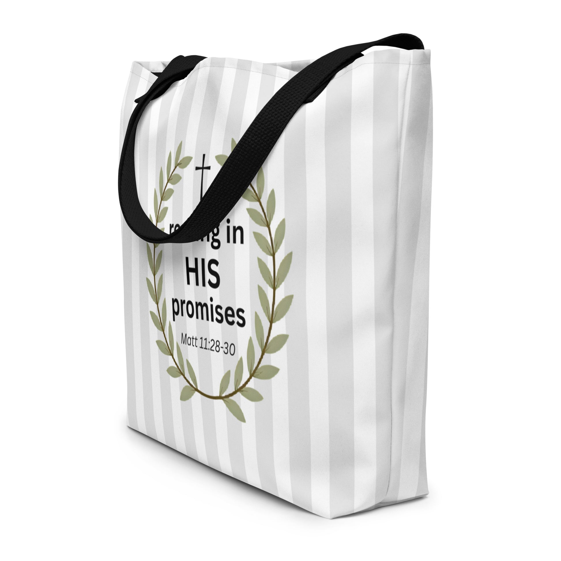 Angled view of the tote showing the striped pattern wrapping around the side, with part of the laurel wreath visible from the front; black straps drape over the top.