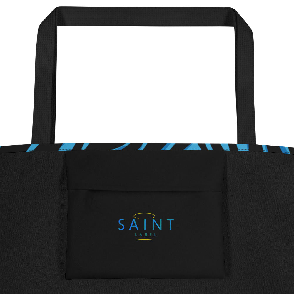 Inside view of the tote showing a black interior pocket with “Saint Label” printed on it in blue; black side panels and straps visible.