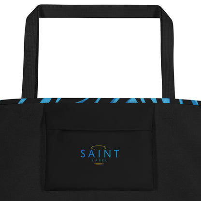 Inside view of the tote showing a black interior pocket with “Saint Label” printed on it in blue; black side panels and straps visible.