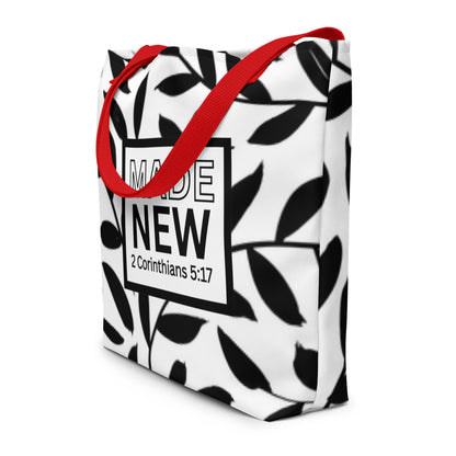 Angled view of black-and-white leaf print tote bag with red straps and “MADE NEW” (2 Corinthians 5:17)