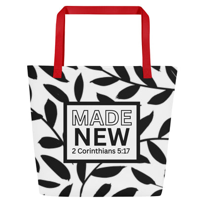 Front view of black-and-white tote bag with red straps, leafy pattern, and boxed text reading “MADE NEW” with “2 Corinthians 5:17.”