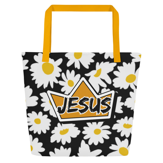 Front view of black tote bag with mustard yellow straps, white daisy print with yellow centers, and a crown graphic with the word “JESUS.”