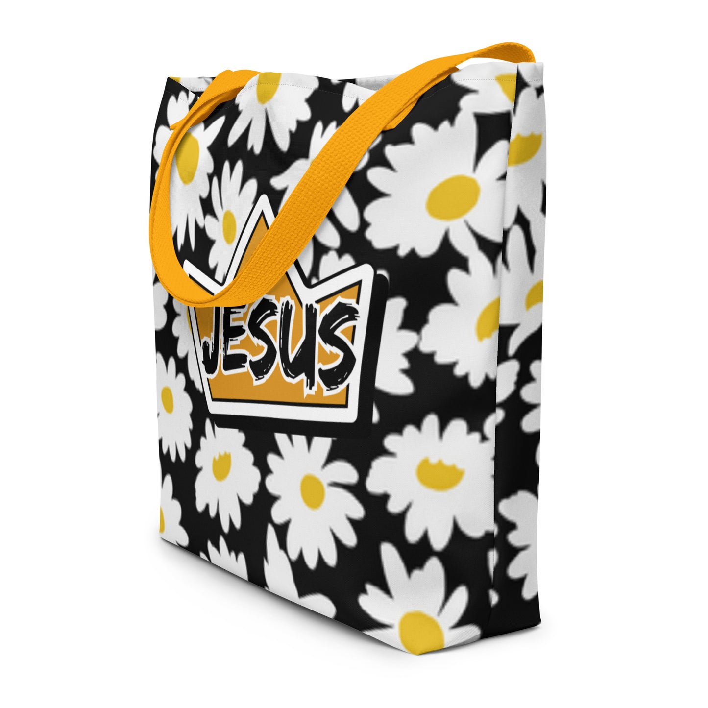 Angled view of daisy print tote bag with mustard yellow straps and “JESUS” crown graphic on the front.