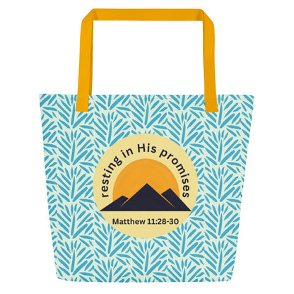 Front view of light blue patterned tote bag with mustard yellow straps and a circle mountain graphic reading “resting in His promises” and “Matthew 11:28–30.”