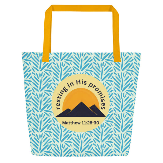Front view of light blue patterned tote bag with mustard yellow straps and a circle mountain graphic reading “resting in His promises” and “Matthew 11:28–30.”