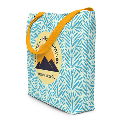 Angled view of light blue patterned tote bag with mustard yellow straps and “resting in His promises” mountain graphic with Matthew 11:28–30.