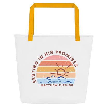White tote bag with mustard-yellow straps featuring a retro sunset graphic over blue waves; text arcs above the graphic reading “RESTING IN HIS PROMISES,” with “MATTHEW 11:28–30” printed beneath.