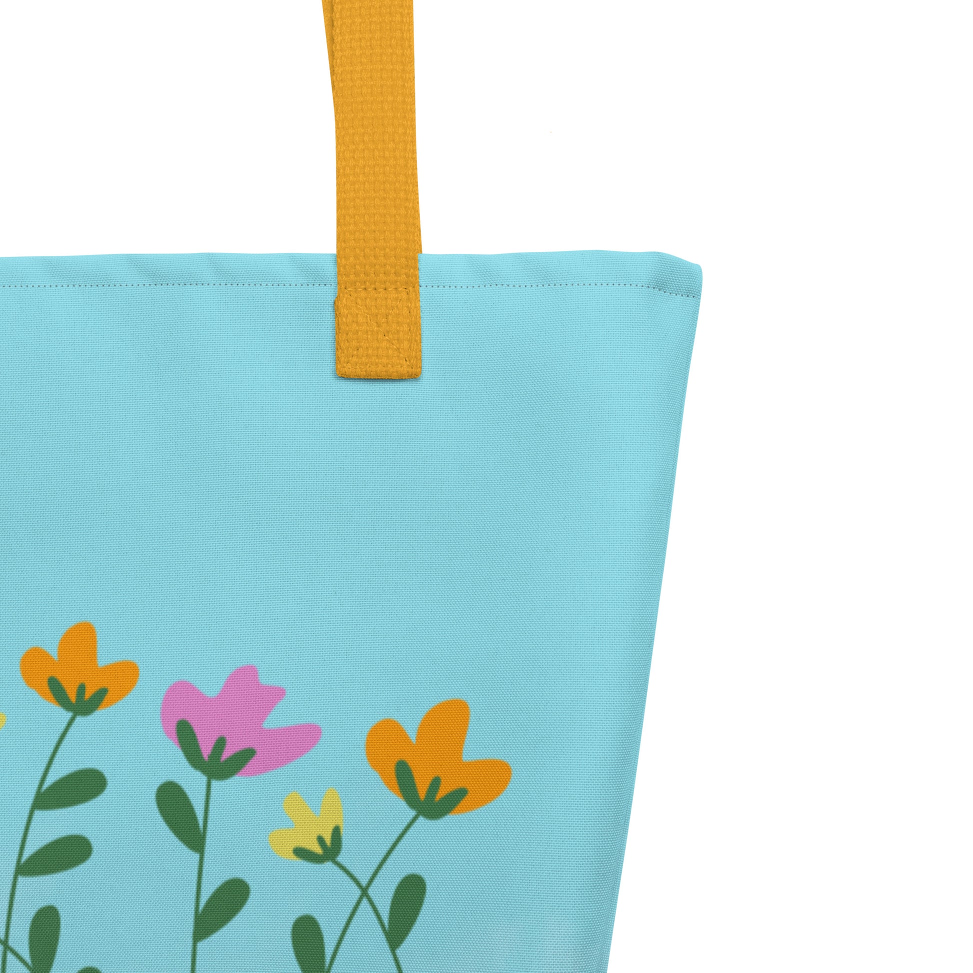 Close up of the tote bag with colorful floral design and yellow handle on a light blue background.