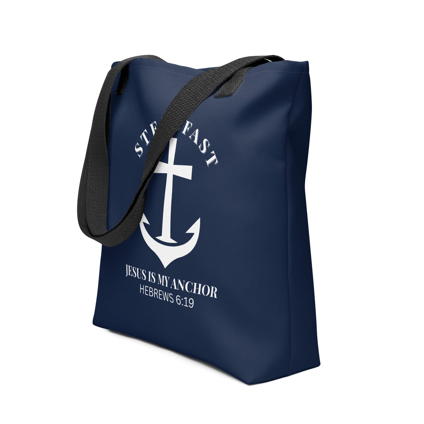 Angled view of the navy tote with black handles, showing the white anchor cross design with “STEADFAST” arched above and “JESUS IS MY ANCHOR” (Hebrews 6:19) underneath.