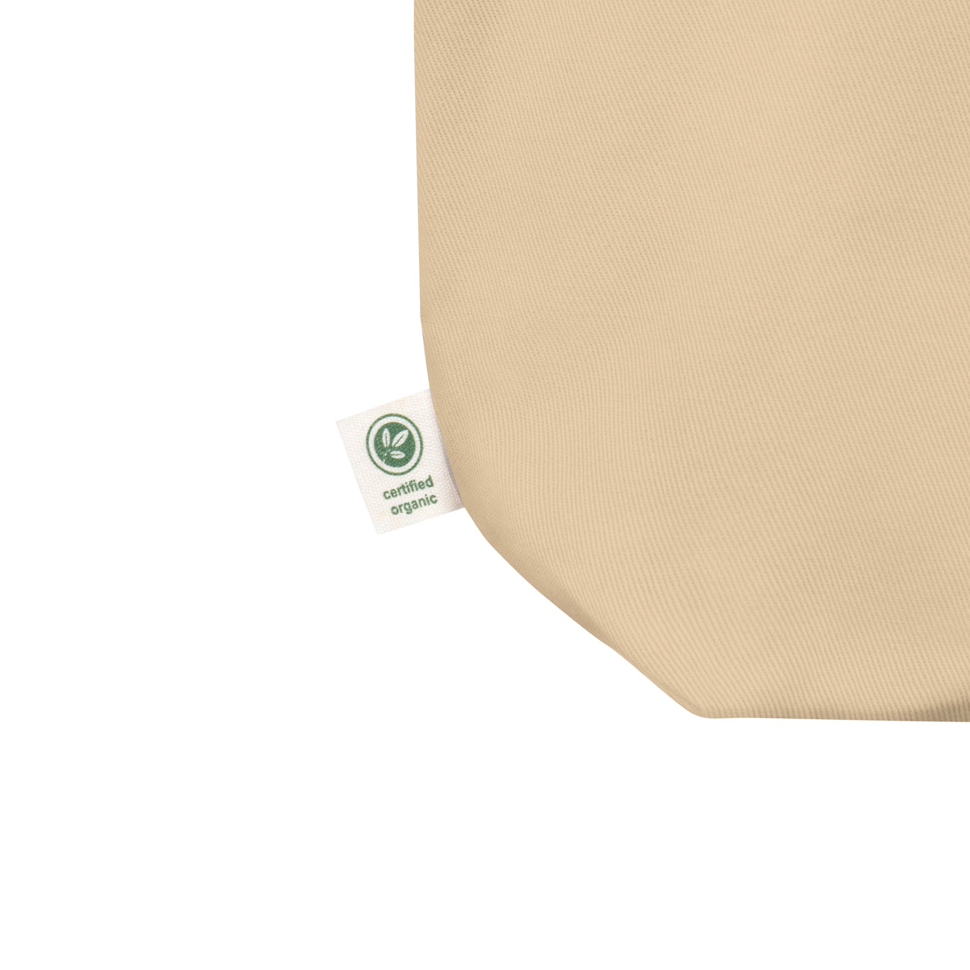 Close-up of a natural cotton Christian tote bag showing the beige fabric texture, certified organic side tag, and part of the “but God” design.