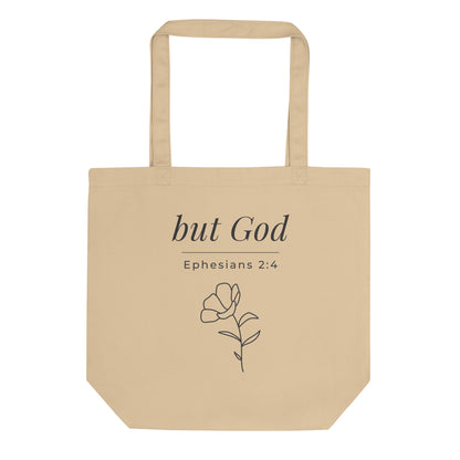 Front view of a natural cotton Christian tote bag with matching beige handles and “but God Ephesians 2:4” text.