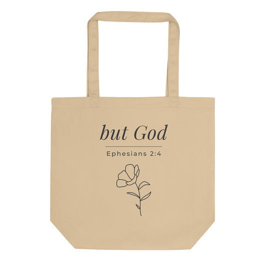Front view of a natural cotton Christian tote bag with matching beige handles and “but God Ephesians 2:4” text.