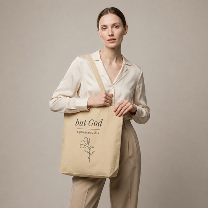 Model carrying a natural cotton Christian tote bag with beige handles and a minimalist “but God Ephesians 2:4” design.