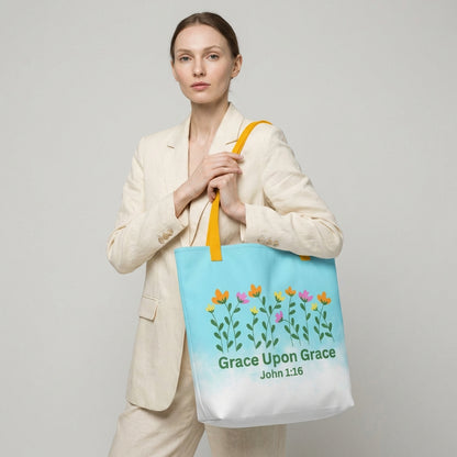 Woman holding a tote bag with floral design and 'Grace Upon Grace' text on a plain background