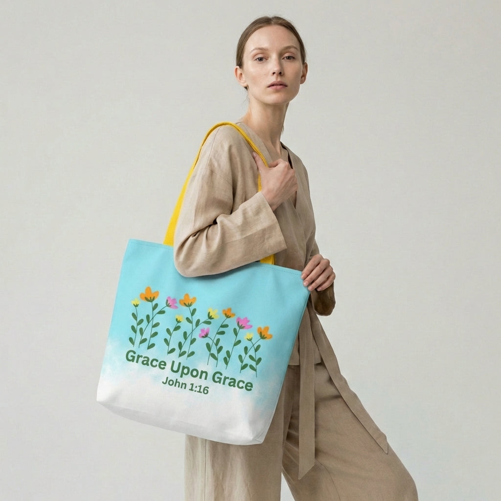 Woman holding a tote bag with floral design and 'Grace Upon Grace' text on a plain background