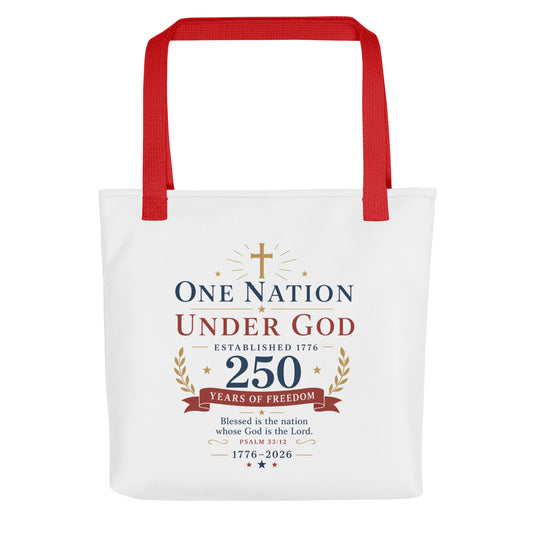 Front view of a white Christian patriotic tote bag with red handles and a “One Nation Under God 250 Years of Freedom” design.