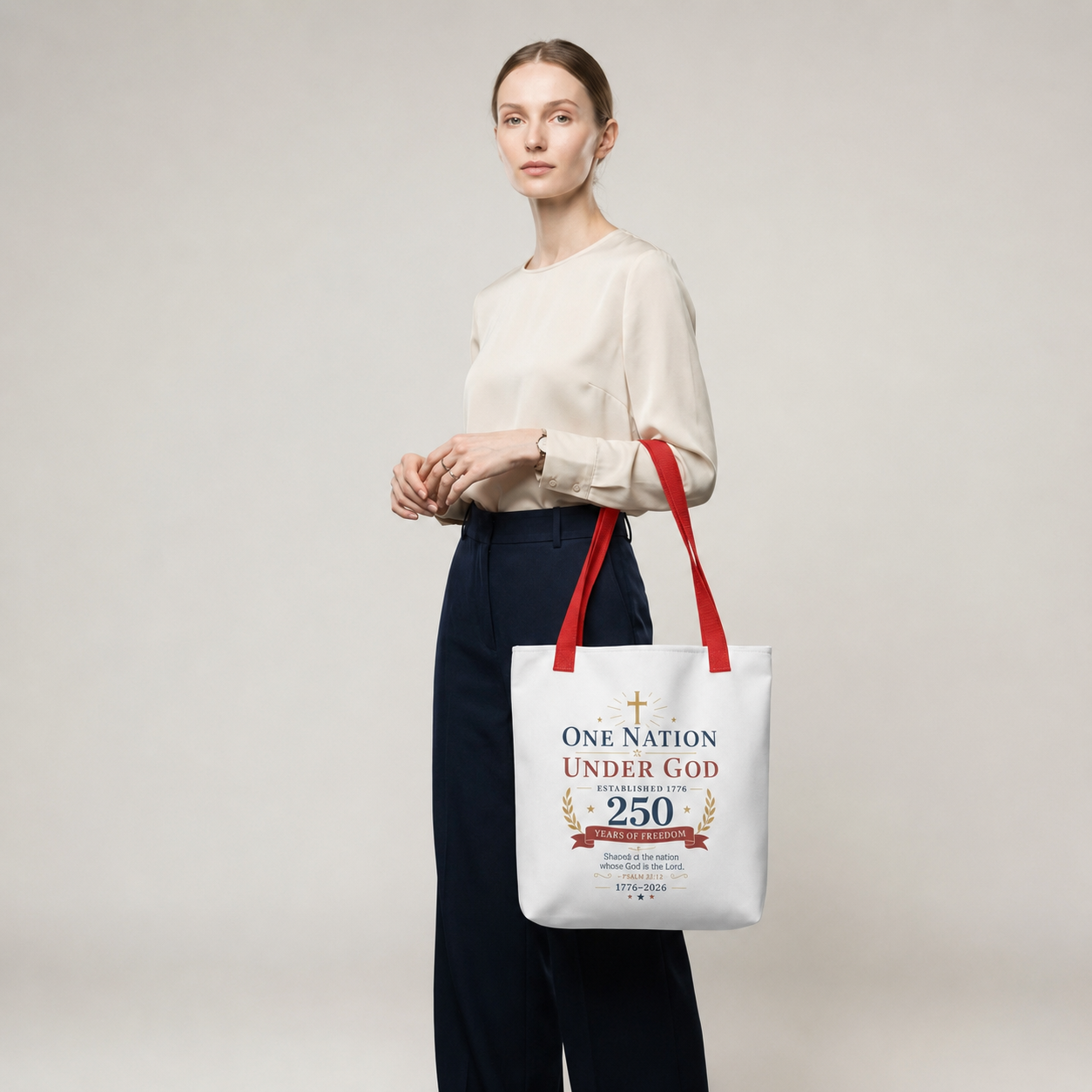 Model carrying a patriotic Christian tote bag with red handles and a faith-based 250 years of freedom design.