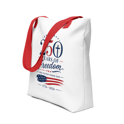 Angled view of a Christian patriotic tote bag featuring red handles, red and blue lettering, stars, a cross, and an American flag design.