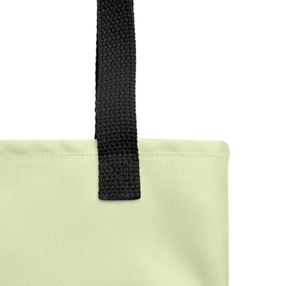 Close-up of a light green Christian tote bag showing the black woven handle, fabric texture, stitching, and soft green material.