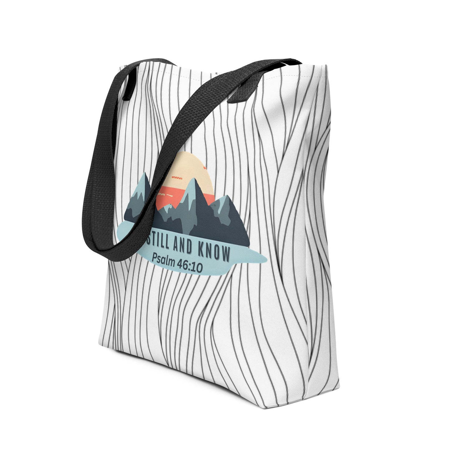 Angled view of the tote with black straps showing the wavy line pattern and “BE STILL AND KNOW — Psalm 46:10” mountain design.