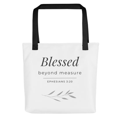 Front view of a white tote bag with black handles featuring “Blessed beyond measure” and “Ephesians 3:20” in dark gray with a leaf design.