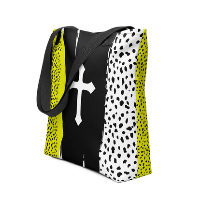 Angled view of the black-handled tote showing the color-block design—neon yellow speckle on one side, white speckle on the other, and a white cross centered on a black painted-style stripe.