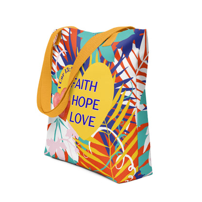 Angled view of a colorful tropical floral tote bag with mustard-yellow handles featuring “Faith Hope Love” and “1 Corinthians 13:13” on a yellow heart.