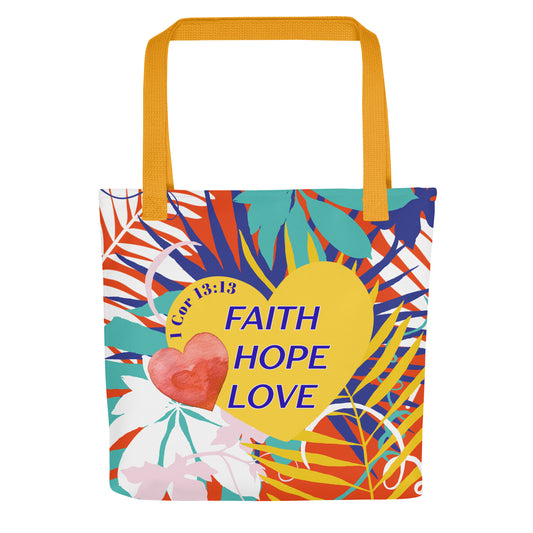 Front view of a colorful floral tote bag with mustard-yellow handles featuring “Faith Hope Love” and “1 Corinthians 13:13” on a yellow heart design.