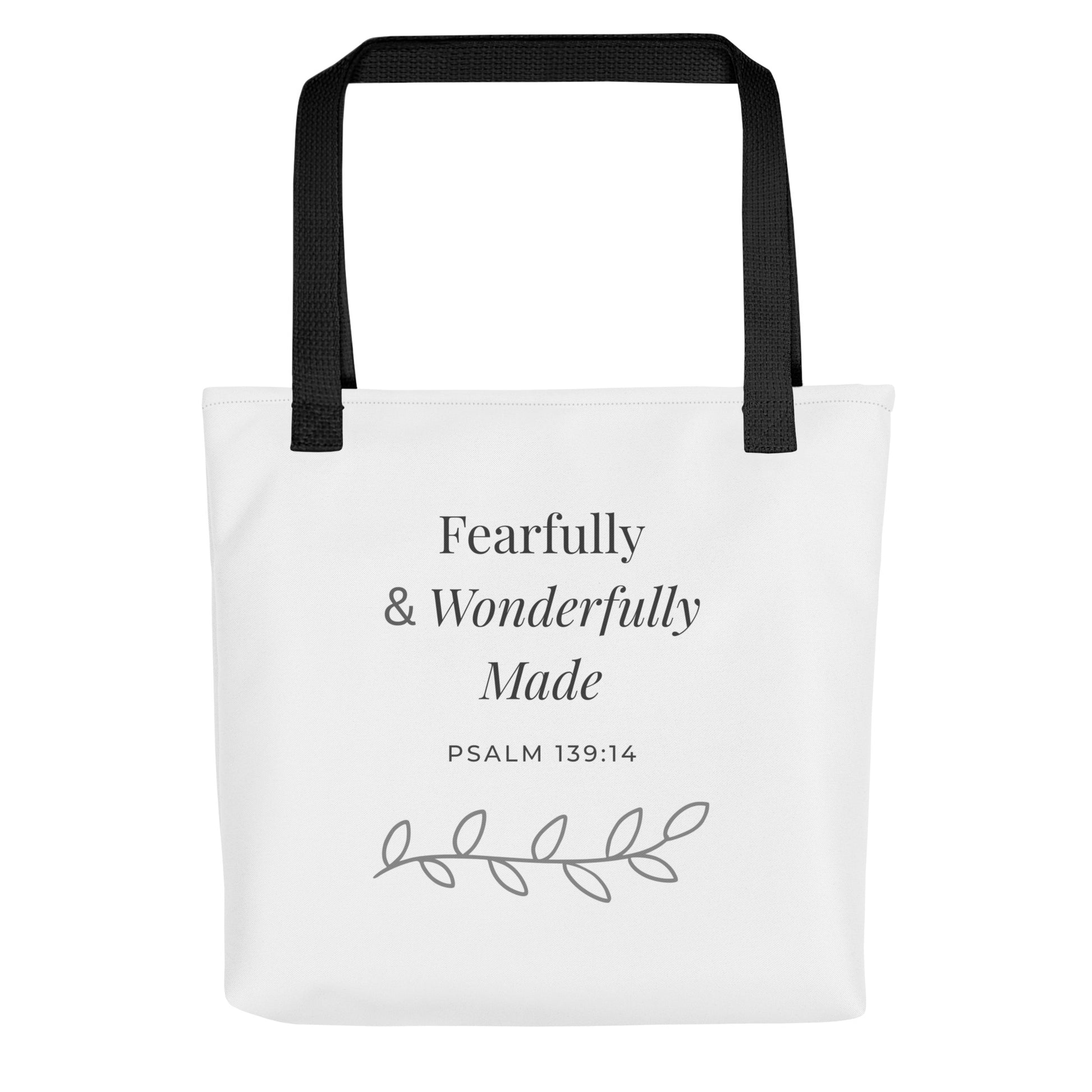 Front view of a white tote bag with black handles featuring “Fearfully & Wonderfully Made,” “Psalm 139:14,” and a leaf vine design in dark gray.
