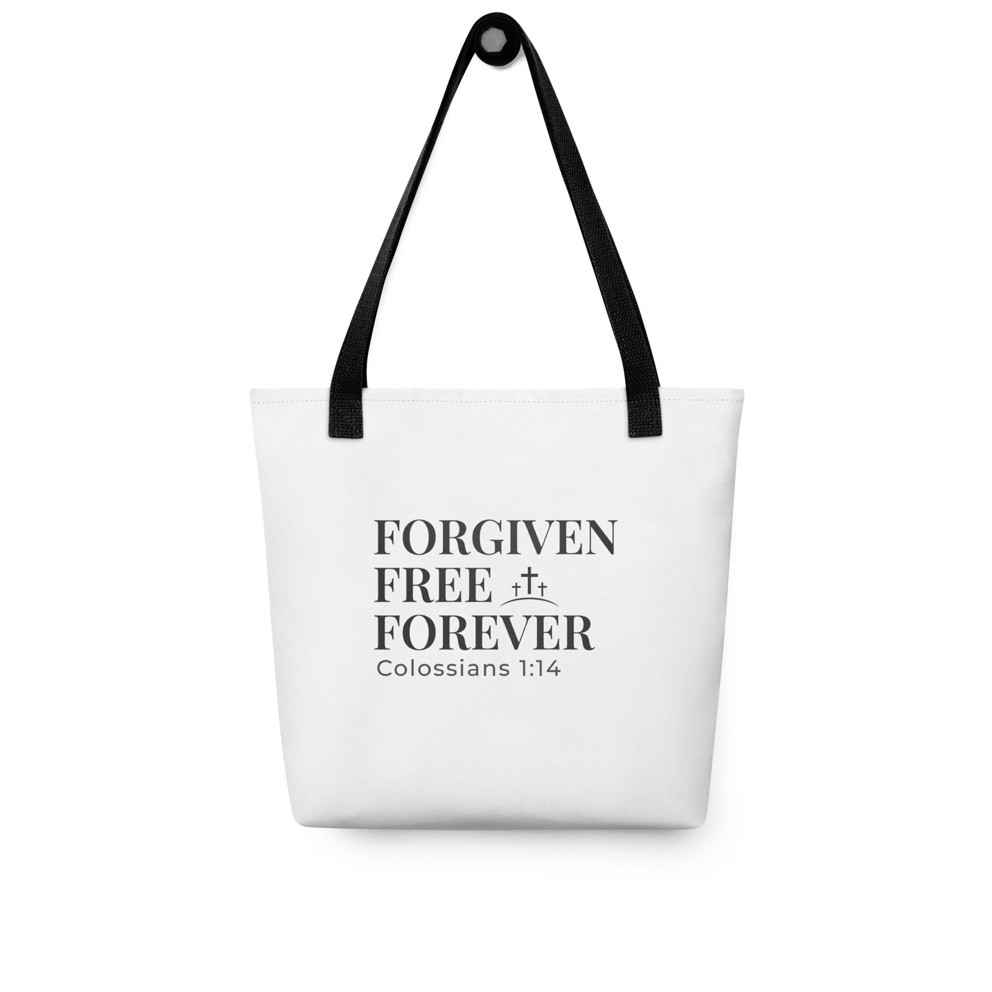 White tote bag hanging on a hook with “Forgiven Free Forever” and the scripture reference “Colossians 1:14.”