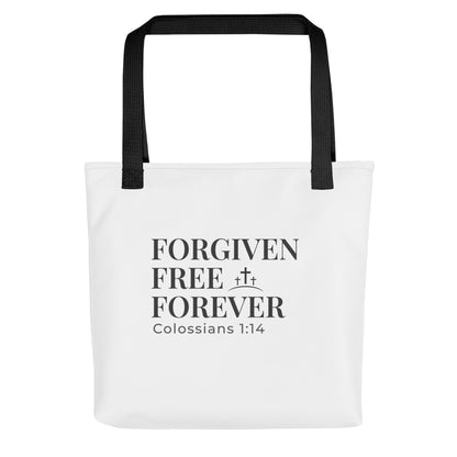 White tote bag with black handles featuring “FORGIVEN FREE FOREVER” and “Colossians 1:14” with a small cross icon.