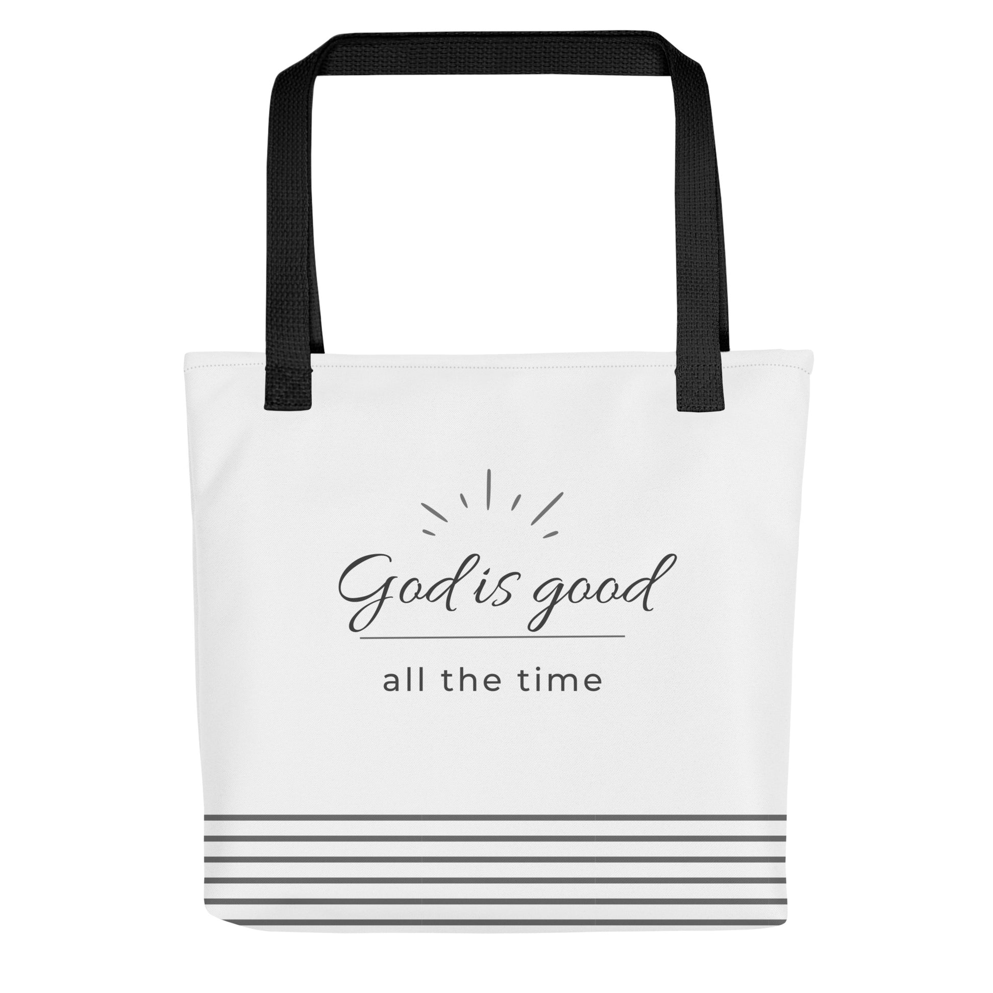 White tote bag with black handles featuring “God is good all the time” in dark gray text and gray stripes along the bottom.