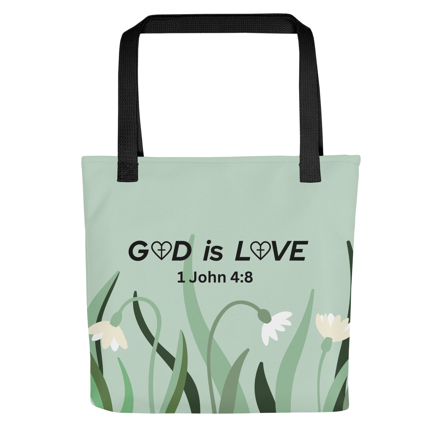 Front view of sage green Christian tote bag with “GOD is LOVE” and “1 John 4:8” text above minimalist white flowers and grass, with black straps.