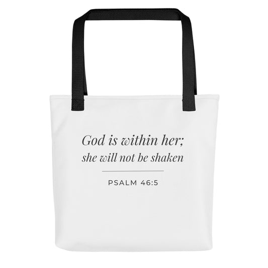 Front view of a white tote bag featuring ‘God is within her; she will not be shaken’ (Psalm 46:5) in dark gray.
