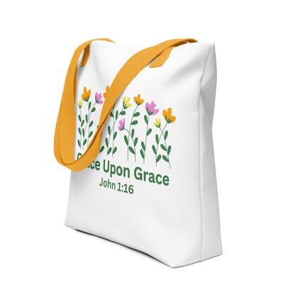 Angled view of the white ‘Grace Upon Grace’ John 1:16 tote bag with mustard-yellow straps and floral graphic above green text.