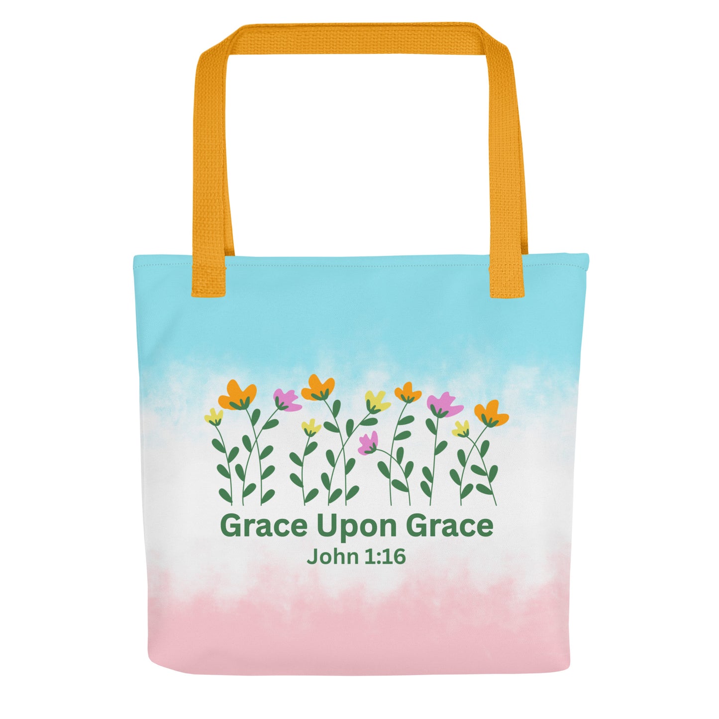 Front view of a pastel blue and pink Christian tote bag with yellow handles, floral artwork, and the text “Grace Upon Grace John 1:16.”