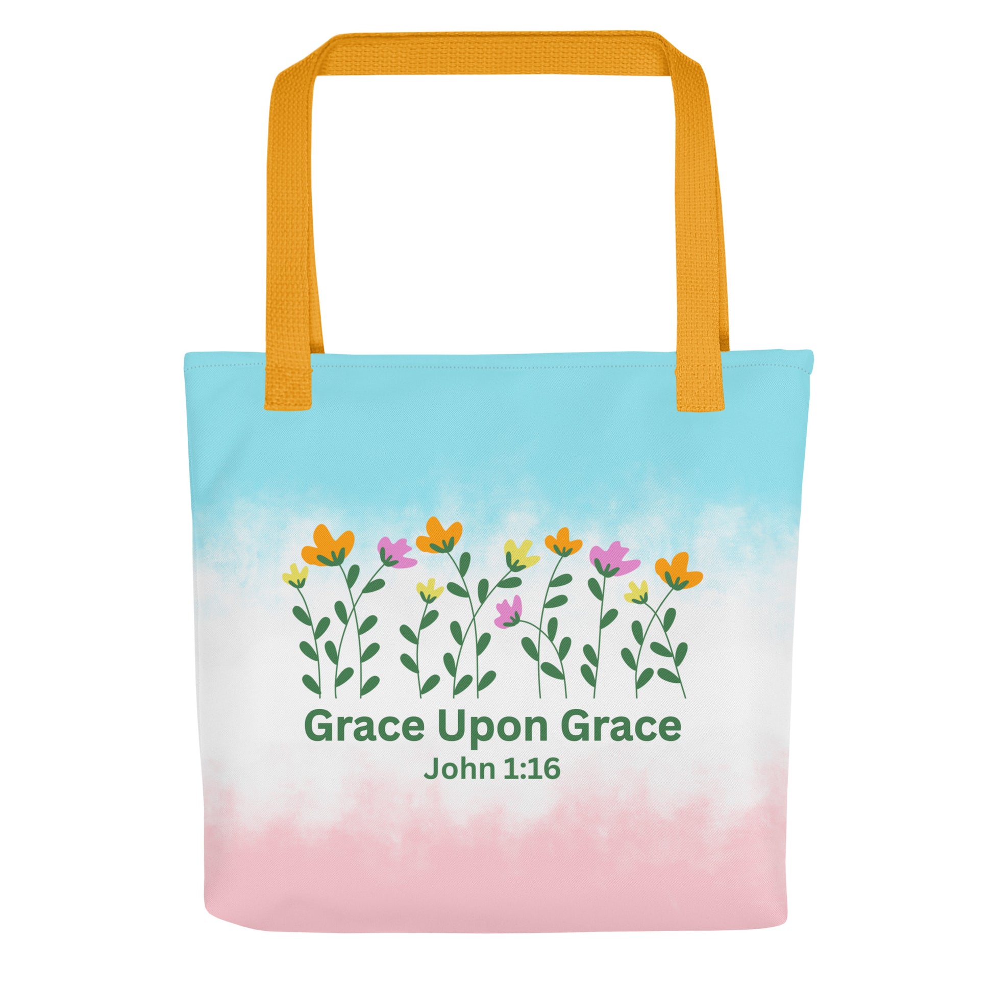 Front view of a pastel blue and pink Christian tote bag with yellow handles, floral artwork, and the text “Grace Upon Grace John 1:16.”