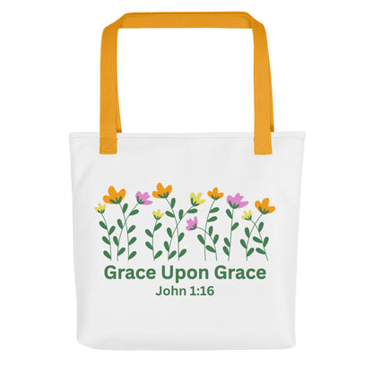 Front view of a white ‘Grace Upon Grace’ John 1:16 tote bag with mustard-yellow straps and floral graphic above green text.