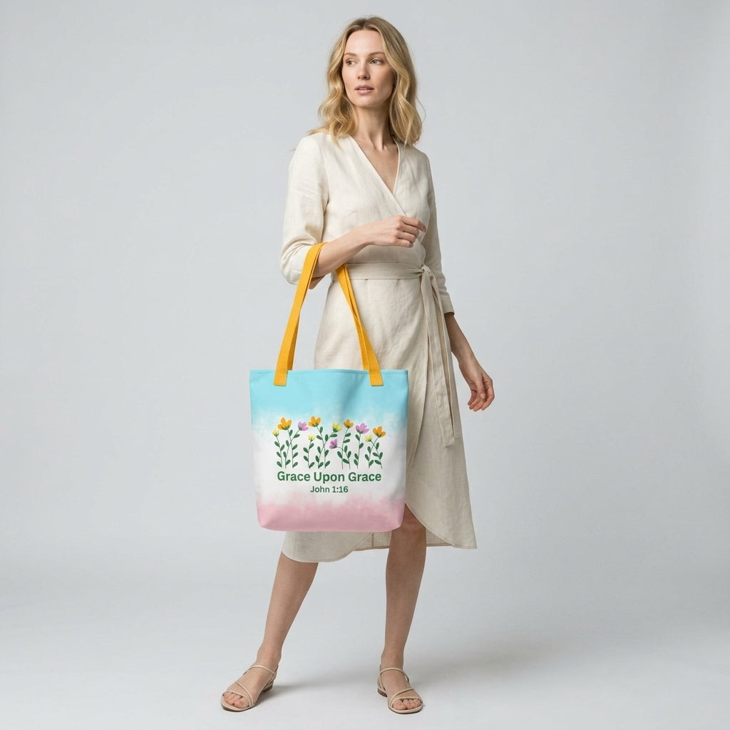 Model carrying a pastel Christian tote bag with yellow handles, floral details, and the Bible verse phrase “Grace Upon Grace John 1:16.”