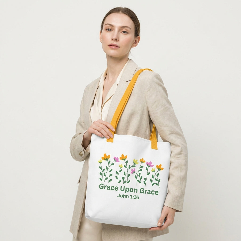 Model wearing the white ‘Grace Upon Grace’ John 1:16 tote bag with mustard-yellow straps and floral design.