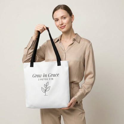 Lifestyle photo of a model holding a white tote bag with black handles featuring “Grow in Grace,” “2 Peter 3:18,” and a plant design in dark gray.