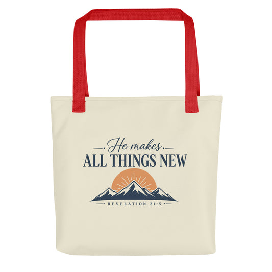 Front view of a cream Christian tote bag with red handles, mountain artwork, a sunrise, and the text “He Makes All Things New Revelation 21:5.”